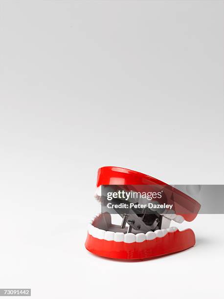 toy chattering teeth, white background - wind up toy foto e immagini stock