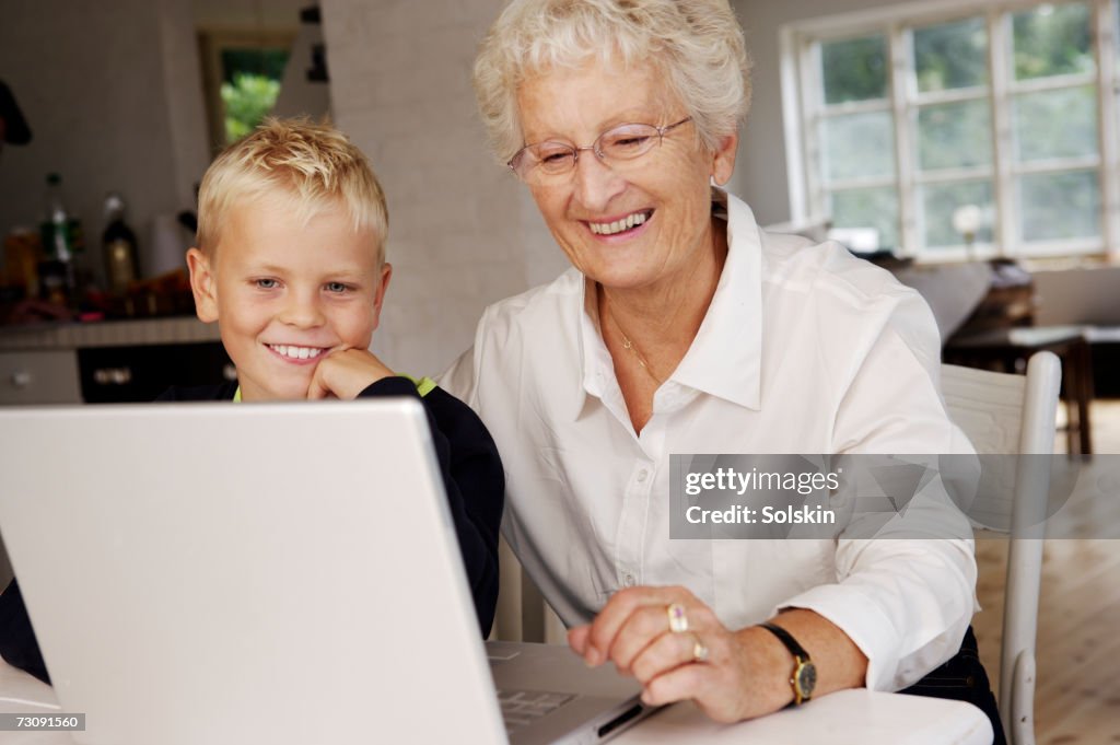 Grandmother and grandson (10-11) using laptop together