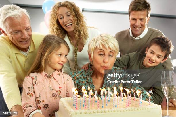 three generational family with children (5-10 years), grandmother blowing out candles on birthday cake - 40 44 years woman caucasian stockfoto's en -beelden