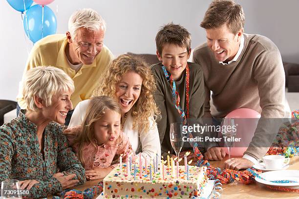 three generational family with children (5-10 years), granddaughter blowing out candles on birthday cake - 4 5 years balloon stock pictures, royalty-free photos & images