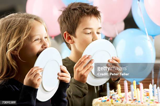 children (5-10 years) licking plates at birthday party - 4 5 years balloon stock pictures, royalty-free photos & images