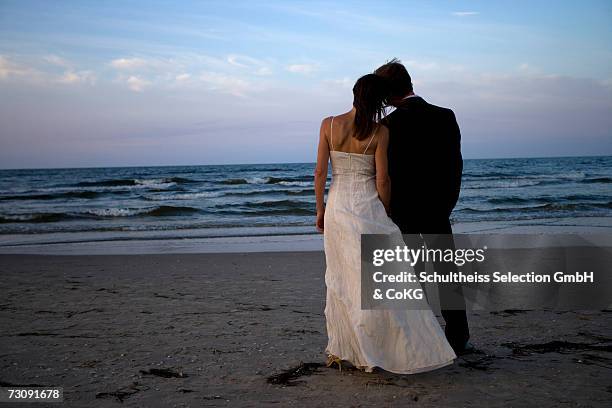 bride and groom on beachrear view - frisch verheiratet stock-fotos und bilder