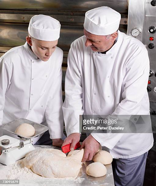 master baker kneading dough, teaching teenage (16-17) assistant - round loaf stock pictures, royalty-free photos & images