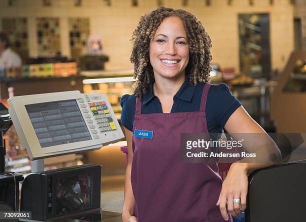 female cashier smiling, portrait - supermarket cashier stock pictures, royalty-free photos & images