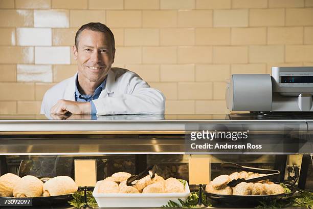 smiling shop assistant leaning on counter top, portrait - deli counter stock pictures, royalty-free photos & images