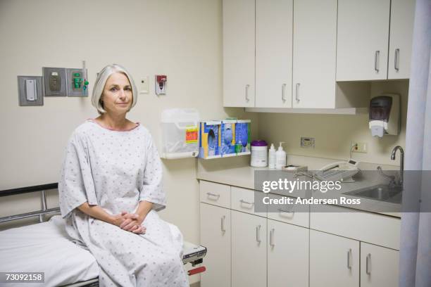 senior female patient sitting on examination table, portrait - sala-de-reconocimiento-médico fotografías e imágenes de stock