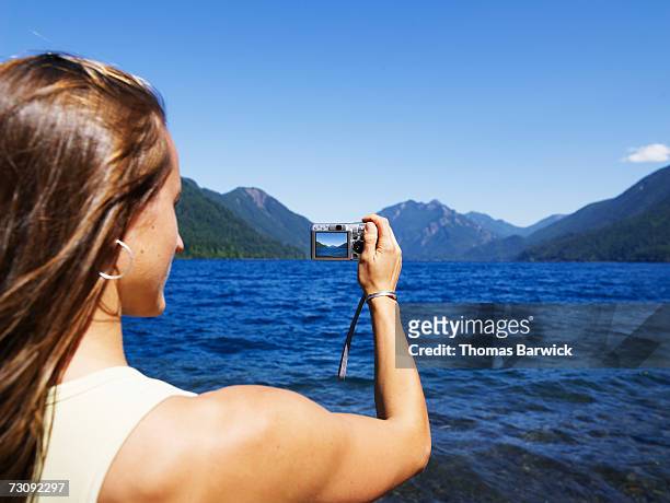 woman taking photo of lake, washington, usa - lago crescent foto e immagini stock