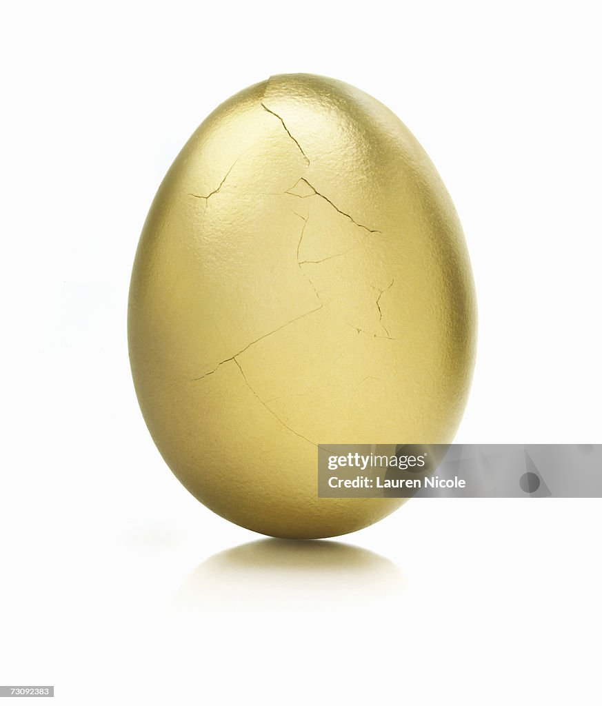 Golden egg, cracks on surface, close up