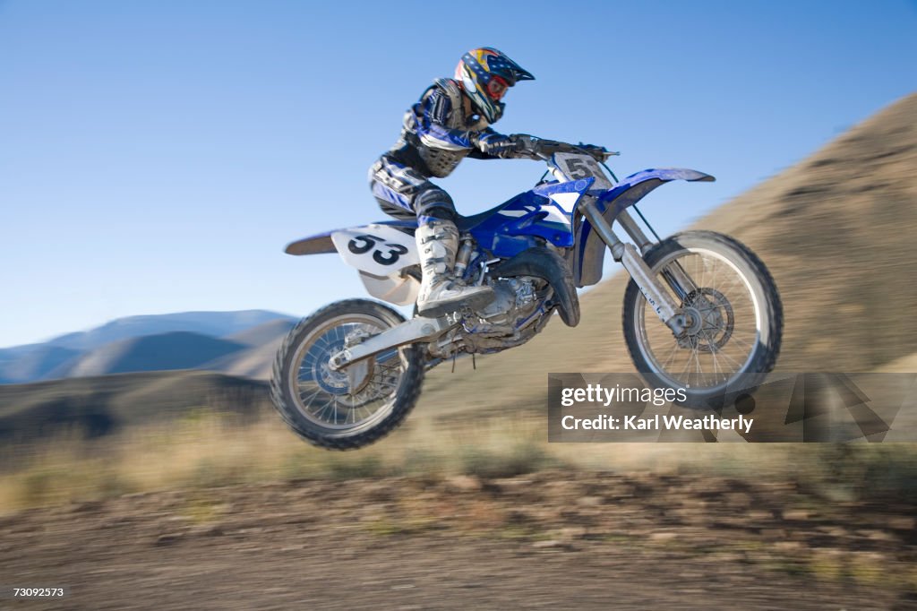 Teenage boy (13-15) motorbiking down dirt road