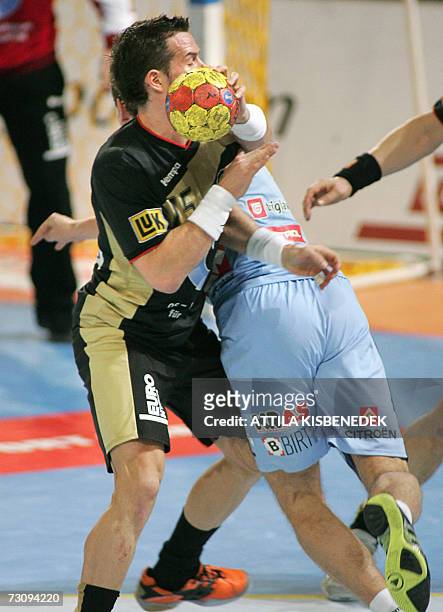 German Torsten Jansen fights for the ball with Slovenian David Spiler during their main round Group I match of the 2007 men's Handball World...
