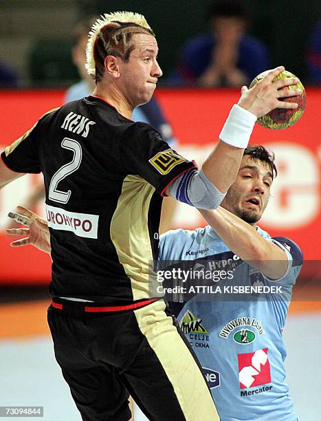 German Pascal Hens is fouled by Slovenian David Spiler during their main round Group I match of the 2007 men's Handball World Championship, 24...