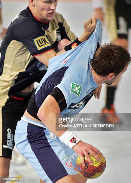 Slovenian Zoran Lubej is fouled by German Lars Kaufmann during their main round Group I match of the 2007 men's Handball World Championship, 24...