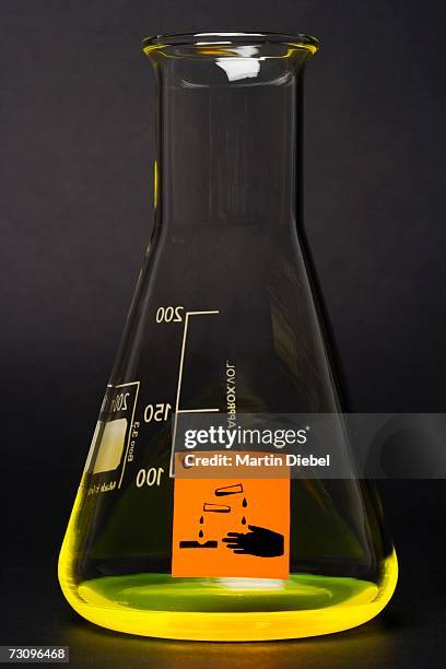 ?corrosive? label on conical flask containing yellow liquid - säure stock-fotos und bilder