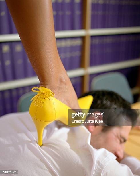 woman wearing high heels and standing on top of a businessman - vingança - fotografias e filmes do acervo