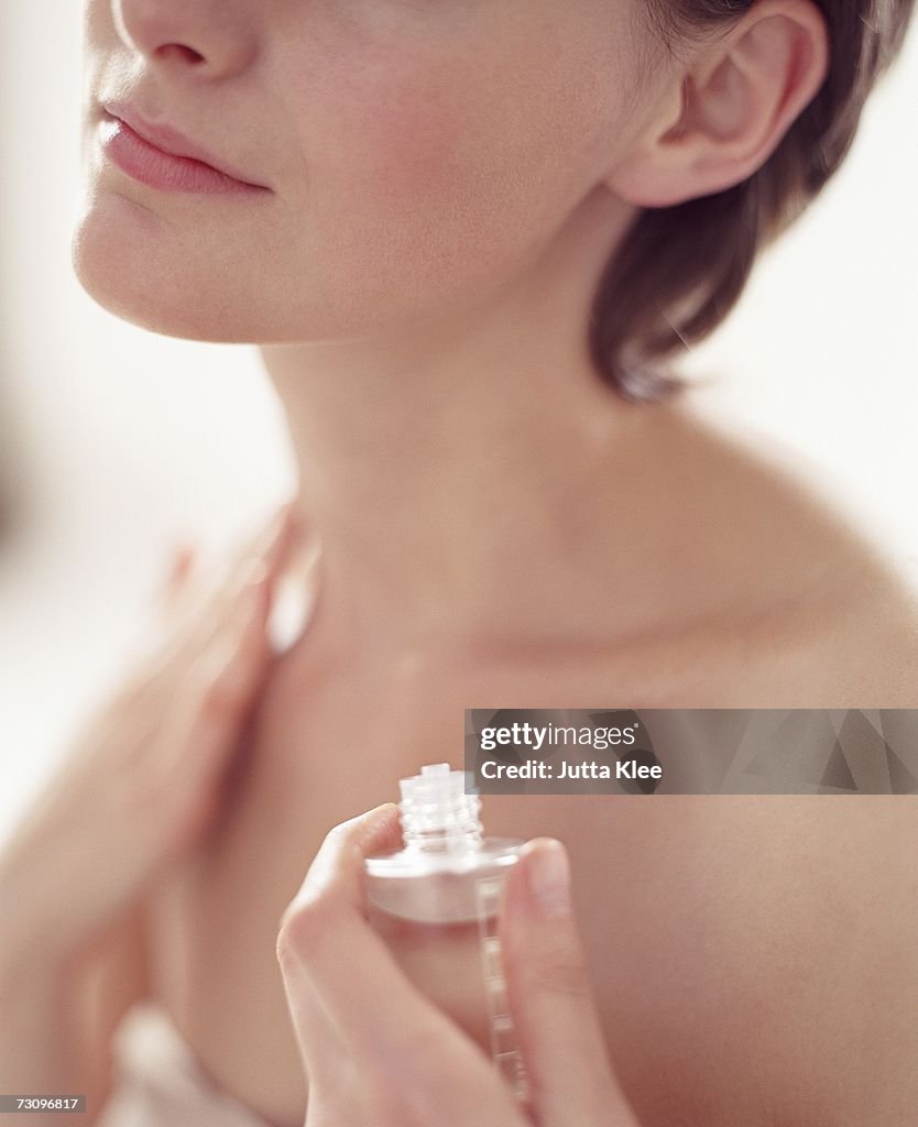 Woman applying essential oil to skin