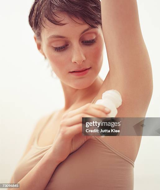 woman applying deodorant - unter dem arm stock-fotos und bilder