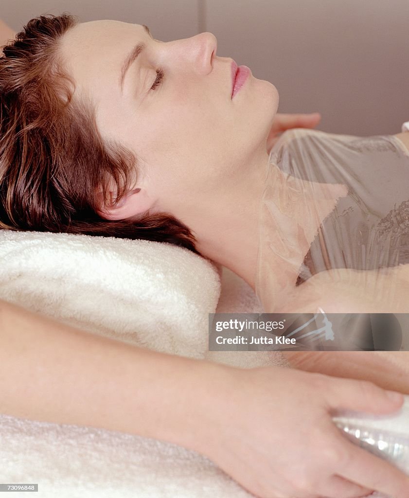 Woman having body mask at beauty spa