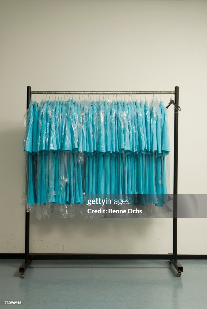 Row of blue shirts hanging on clothes rack