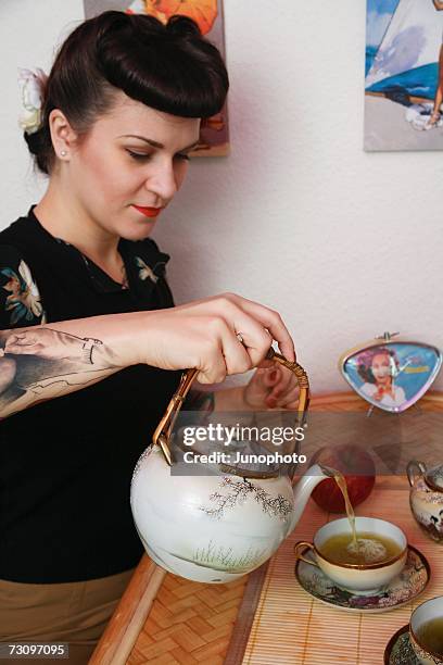 young rockabilly woman pouring tea - rockabilly stock pictures, royalty-free photos & images