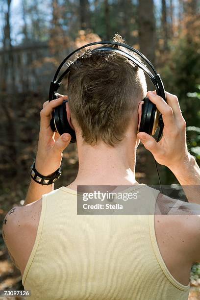 man standing in the woods and wearing headphones - spiked bracelet stock pictures, royalty-free photos & images