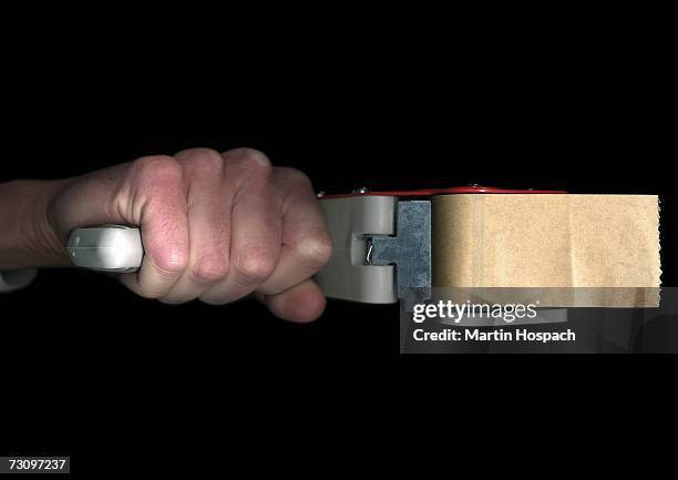 man holding an industrial tape dispenser - tape dispenser stock pictures, royalty-free photos & images