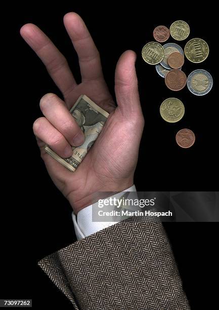 man holding us banknotes beside pile of euro coins - fünfzig euro cent stock-fotos und bilder