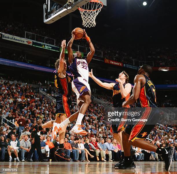 James Jones of the Phoenix Suns takes the ball to the basket against Mike Dunleavy, Troy Murphy and Kelenna Azubuike of the Golden State Warriors...
