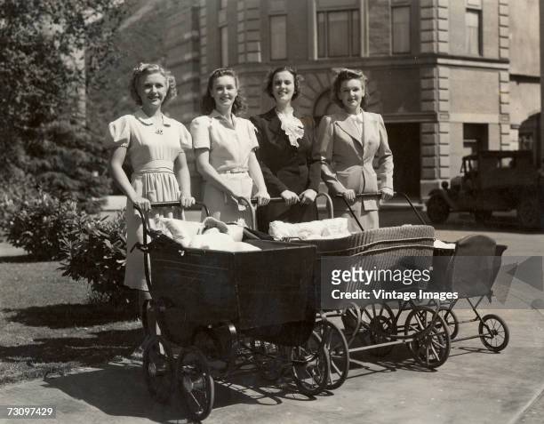 American singers and actresses the Lane Sisters, with actress Gail Page, posing with baby carriages containing baby dolls, in a promotional portrait...