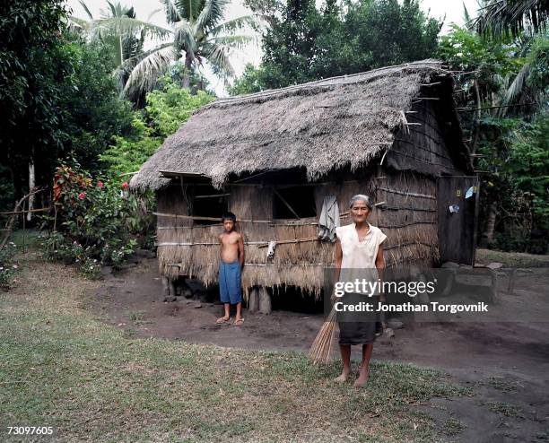Woman stands in front of her traditional straw house, June 1 abuyan Claro Island, Philippines.This is how most of the people on the Island live.