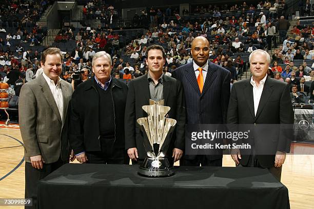 Jimmie Johnson, 2006 NASCAR driver of the year, is presented with a Bobcats jersey and the Nextel Cup trophy with Mark Dyer, NASCAR VP of licensing...