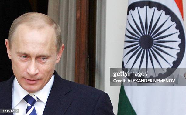 Russian President Vladimir Putin walks past an Indian national flag prior to a meeting with Indian Prime Minister Manmohan Singh in New Delhi, 25...