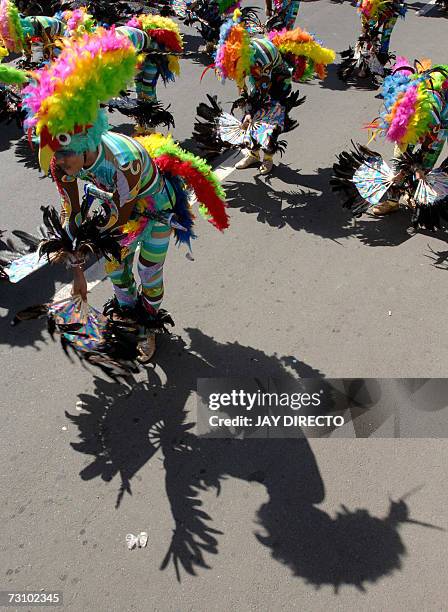 Performers dancing in the street holding a religious icon of the Santo Nino, during the culmination of the nine-day religious festival called...