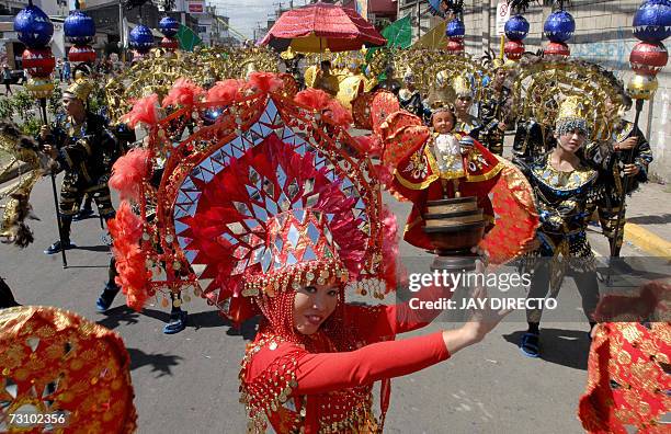 Performers dancing in the street holding a religious icon of the Santo Nino, during the culmination of the nine-day religious festival called...