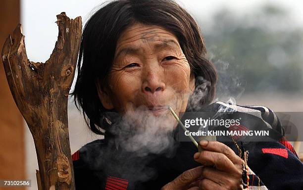 This picture taken 16 January 2007 shows a tribal woman enjoying her home-made pipe in Lahe of Khamti Township in northwestern Myanmar bordering...