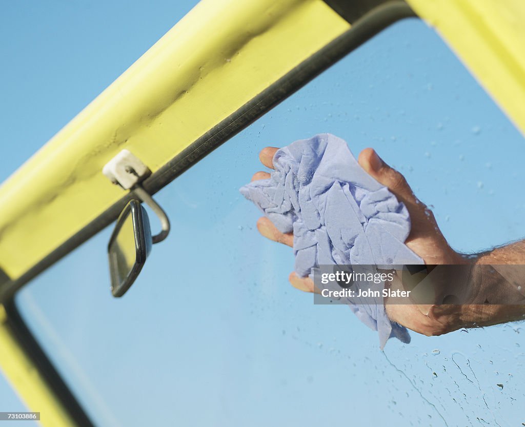 Man washing windscreen, close-up, low angle view