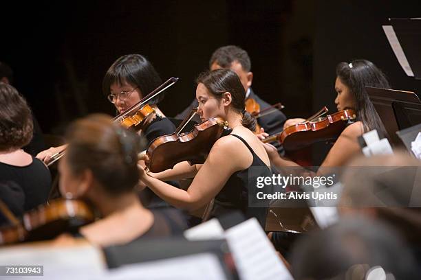 violins performing in symphony orchestra - soloist stock-fotos und bilder