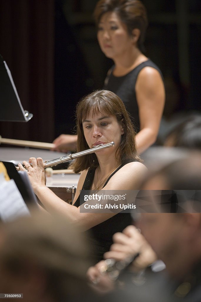 Flutist in symphony orchestra during performance