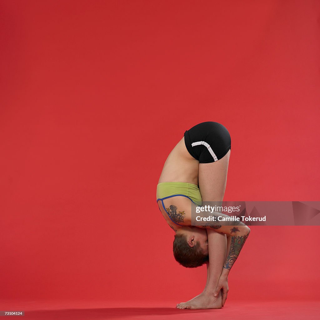 Young woman doing yoga, forward bend position