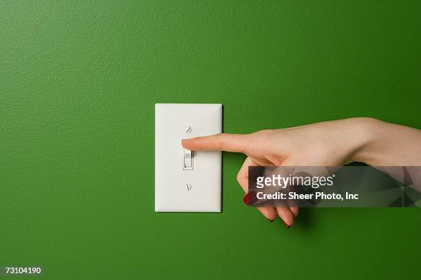 woman's hand on switch - light switch stock pictures, royalty-free photos & images