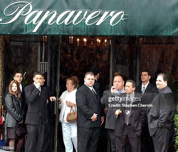 Friends and family stand in front of the Papavero funeral home to attend the wake for mobster John Gotti, June 14, 2002 in the Queens borough of New...
