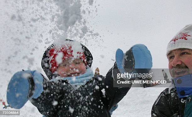 Oberwiesenthal, GERMANY: Three years old Quentin enjoys playing in the snow as his grandfather looks on 25 January 2007 on the Fichtelberg mountain...