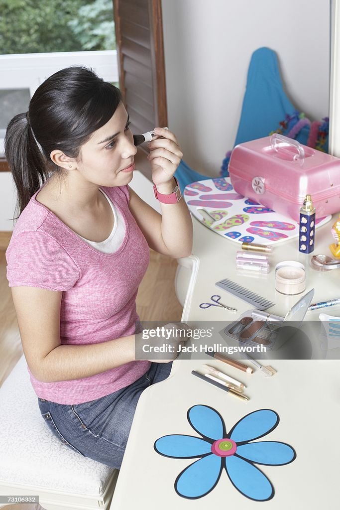 Side profile of a teenage girl putting on makeup