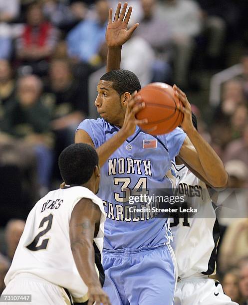 Brandan Wright of the University of North Carolina Tar Heels looks on move the ball against Shamaine Dukes and Jamie Skeen of the Wake Forest Demon...