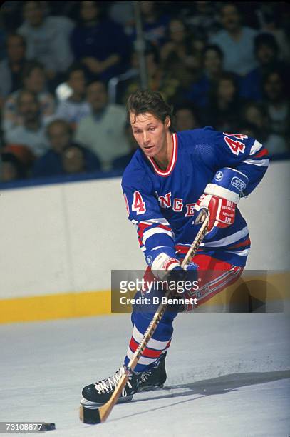 Canadian hockey player Ron Duguay of the New York Rangers skates with the puck during a game, late 1980s.