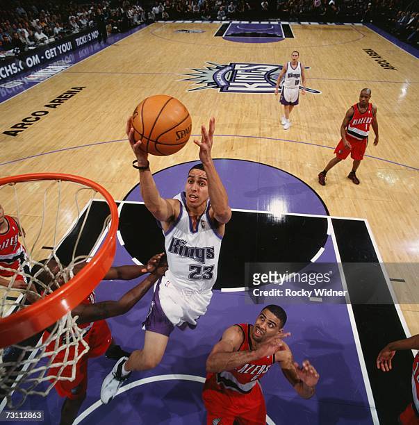 Kevin Martin of the Sacramento Kings drives to the basket for a layup against Zach Randolph and Ime Udoka of the Portland Trail Blazers during a game...