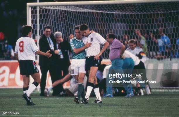 German footballer and captain of the West Germany team, Lothar Matthaus puts his arm around English footballer Chris Waddle as teammate Peter...