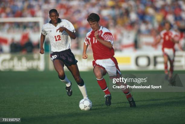 English footballer Carlton Palmer attempts to halt a run by Danish footballer Brian Laudrup in the group 1 match between Denmark and England in the...