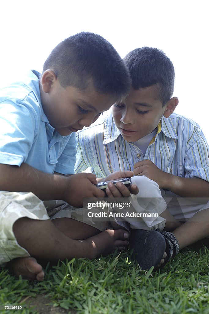 Two boys (6-8) playing with mobile phone