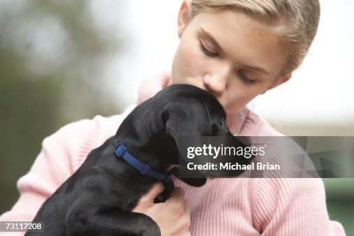 Girl Hugging Black Labrador Puppy Outdoors High-Res Stock Photo - Getty ...