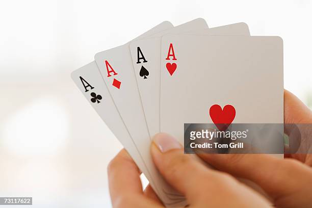 womans hand holding four aces - ace of clubs stock pictures, royalty-free photos & images